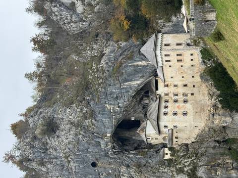       Predjama Castle built into a rocky cliff.
  