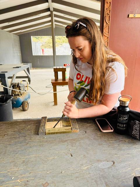       Person engraving on a piece of wood.
  