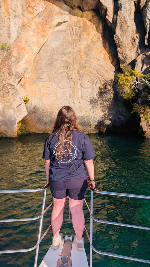       Person looking at a carved rock wall.
  