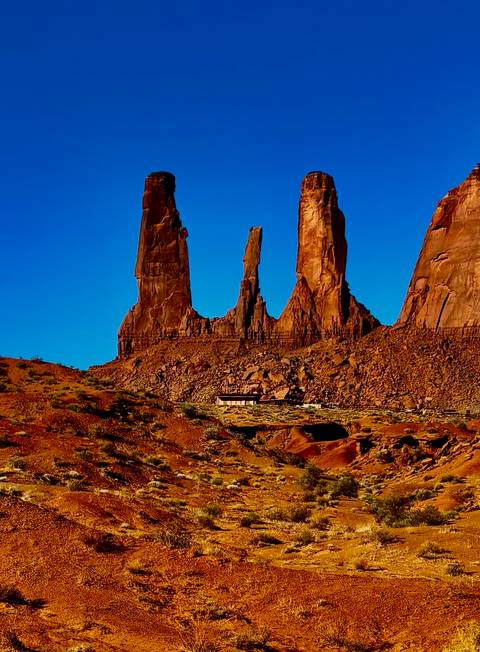 Monument Valley rock formations under clear blue sky.
