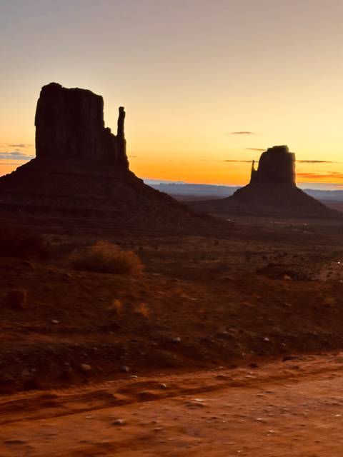      Distant view of Monument Valley formations at sunset.
  