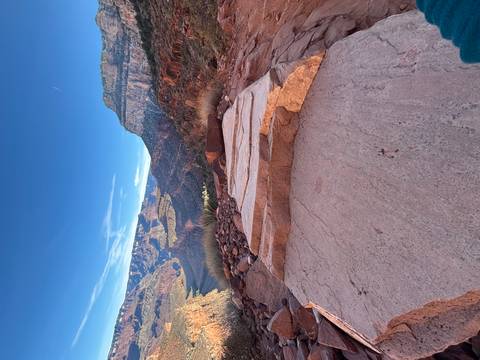 Rocky trail view with canyons and blue sky.