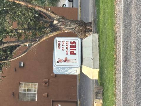 Sign with humorous text on a street in a desert setting.