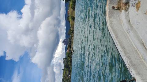       A view from a boat towards a large rock formation in the distance.
  