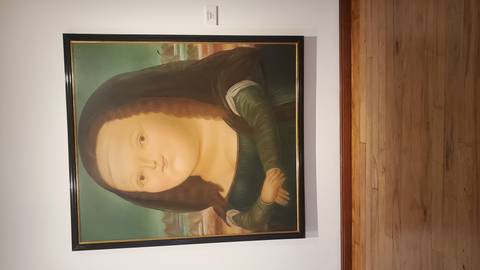       A painting in a museum, featuring a unique depiction of Mona Lisa.
  