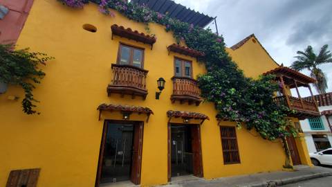       Colorful colonial-style building with flowers climbing the facade.
  