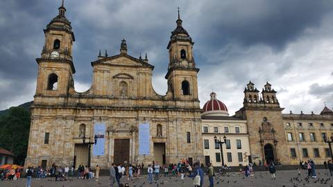       Large cathedral with people congregating in the plaza.
  