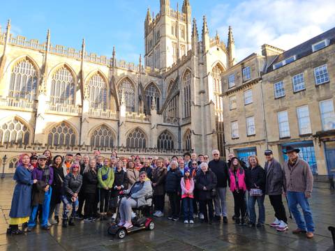 Group of people posing in front of a historic building.