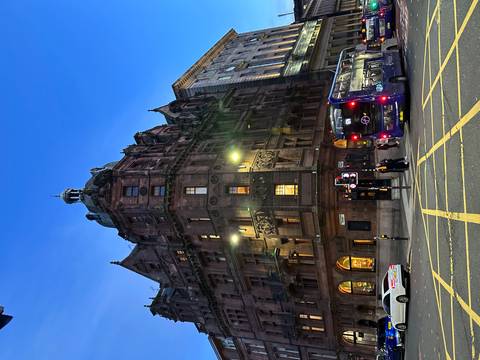 Historic building with a bus on a city street at dusk.