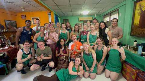       Large group photo in a room with people wearing aprons.
  