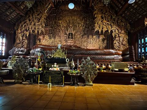       Intricately carved reclining Buddha statue in a temple.
  