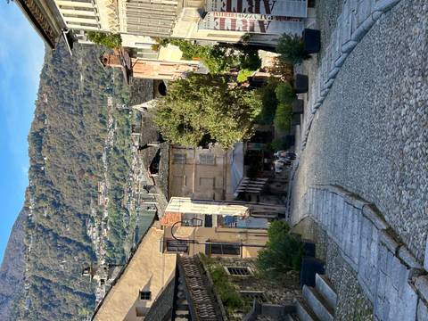 Quaint cobblestone alleyway with distant mountains.