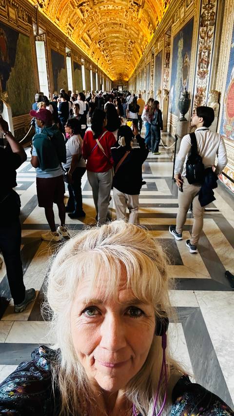 Group of people walking on a paved area with a patterned floor.