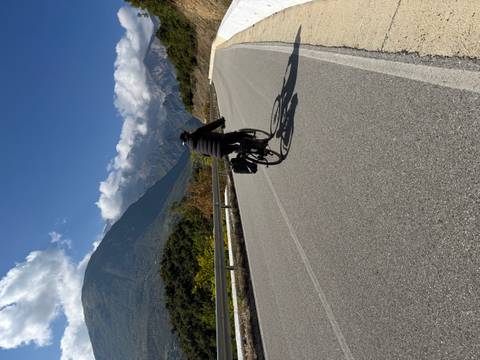 Cyclist on a mountain road with scenic views.