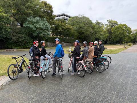 Group of cyclists standing with their bikes in an open area.
