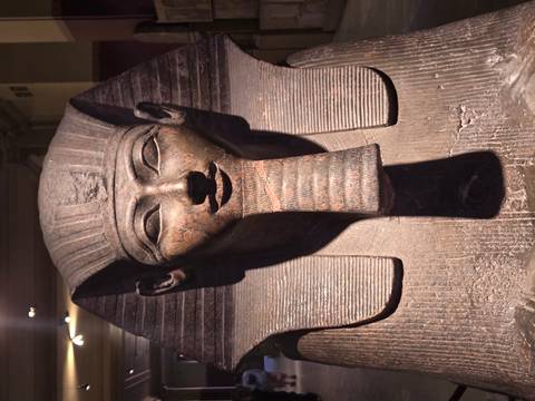 Statue of an Egyptian pharaoh in a museum.