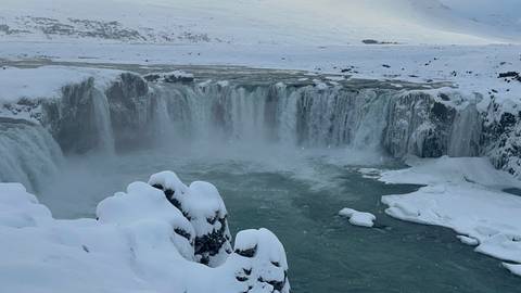 Frozen waterfall cascading over rocky cliffs.