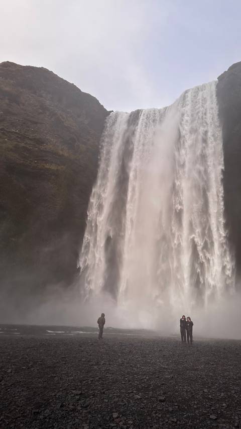       Large waterfall with mist surrounded by lush vegetation.
  