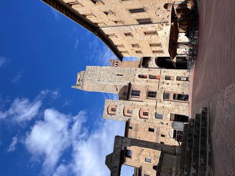 Stone tower in a town square with blue sky.