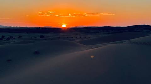       Sunset over sand dunes in the desert.
  