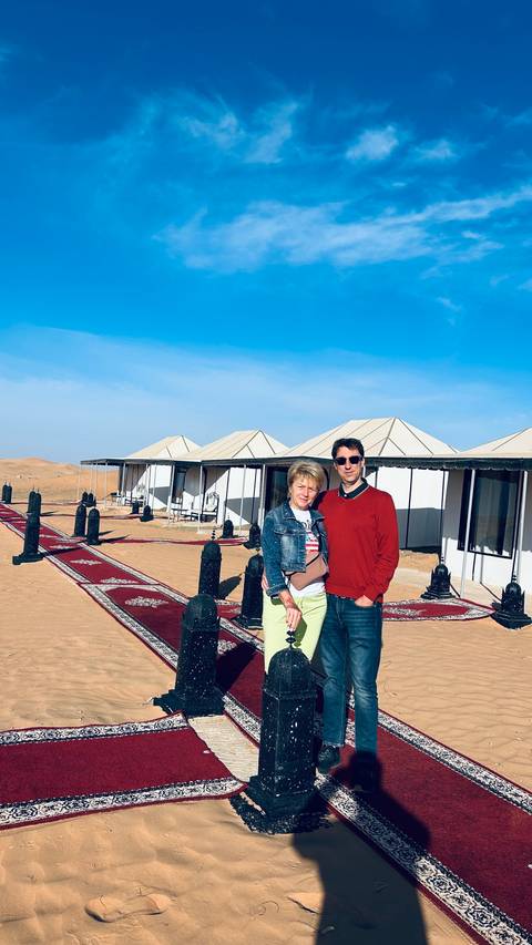 Couple standing in front of desert tents.