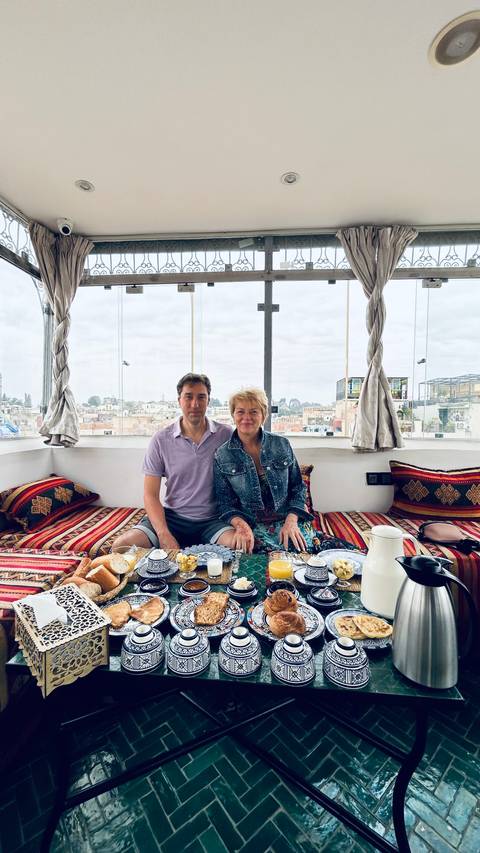 Couple sitting at a table with city view behind.