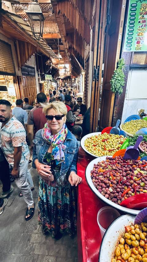       Crowded market with olives on display.
  