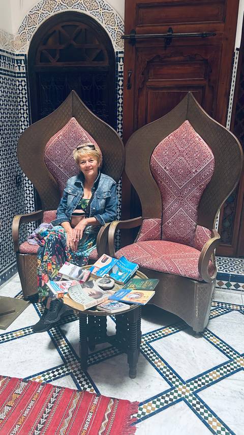 Woman sitting with travel guides and Moroccan literature.