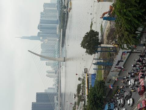       River view with a modern bridge and tall buildings.
  
