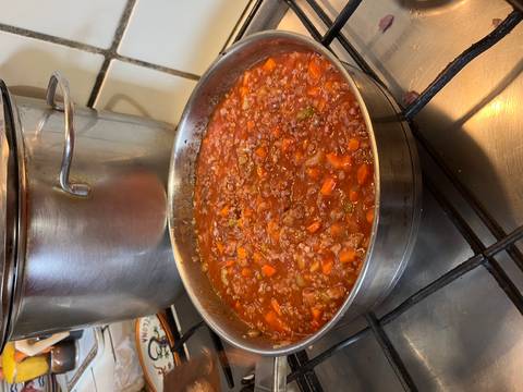 Pan with a hearty stew being cooked on a gas stove.