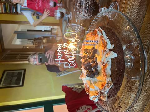 Birthday cake with candles and a person in the background.