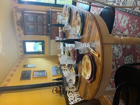 Set dining table in a homely room with paintings on the walls.