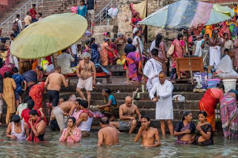 Crowded bathing location with people dressed in traditional attire.