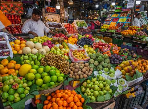       Vibrant fruit market stall with a variety of colorful fruits.
  
