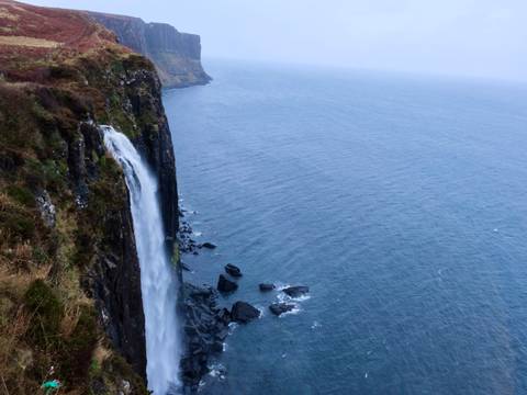 A dramatic cliffside waterfall cascading into the sea.
