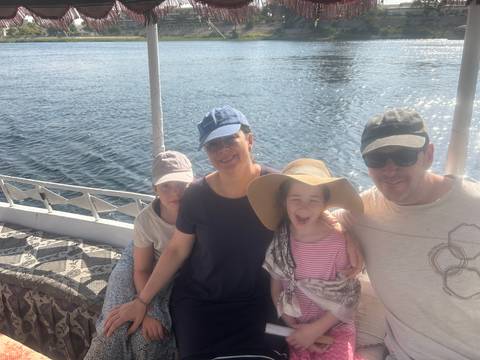       Family enjoying a boat ride on a river.
  