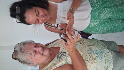       Two people holding small birds indoors.
  