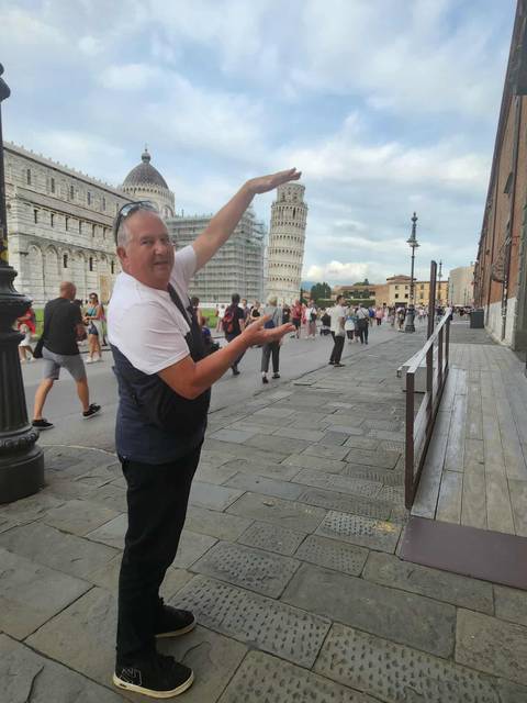 Tourist posing with the Leaning Tower of Pisa.