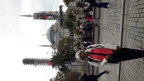 A person posing in front of a mosque under renovation.