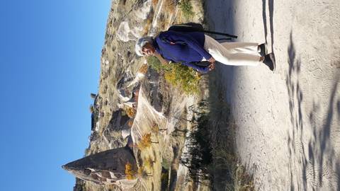       A person standing near unique rock formations.
  