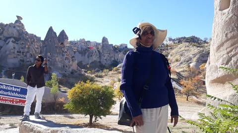 Person viewing rock formations with another exploring in the background.