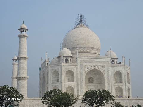 The Taj Mahal under a clear sky with its minarets.