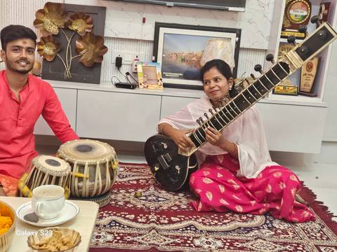 Individuals playing Indian musical instruments.