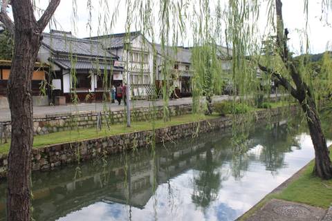 Canal with traditional buildings and trees.