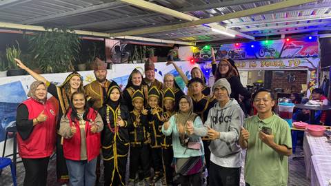       A group of people and locals posing in traditional attire.
  