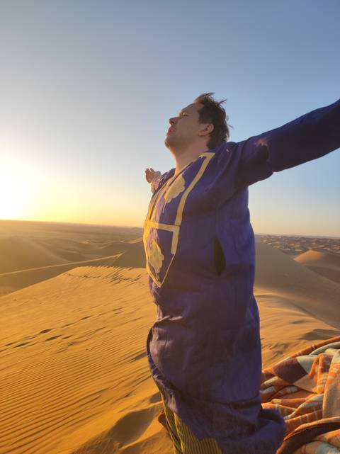       Person enjoying the desert view with arms outstretched.
  