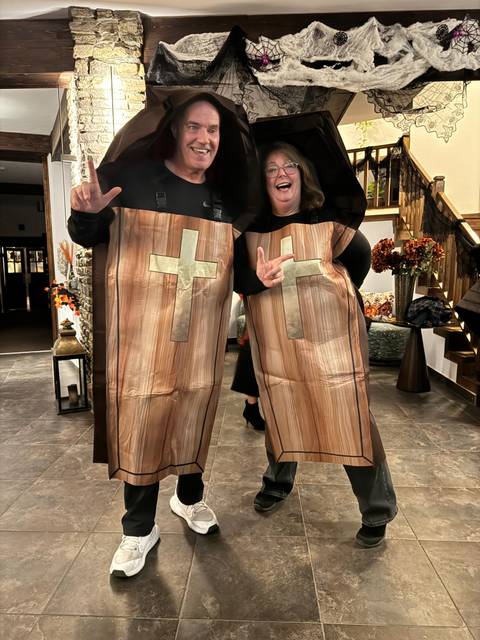       Two people in Halloween costumes posing indoors.
  