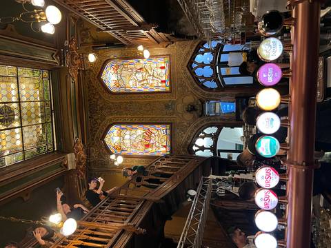 Interior of a pub with stained glass windows and a bar.