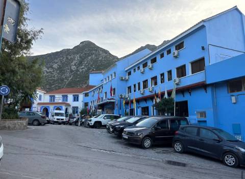       Blue hotel building in a mountainous area in Morocco.
  