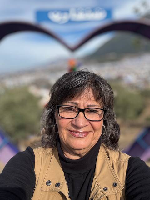       Selfie of a woman with blurred cityscape in the background.
  